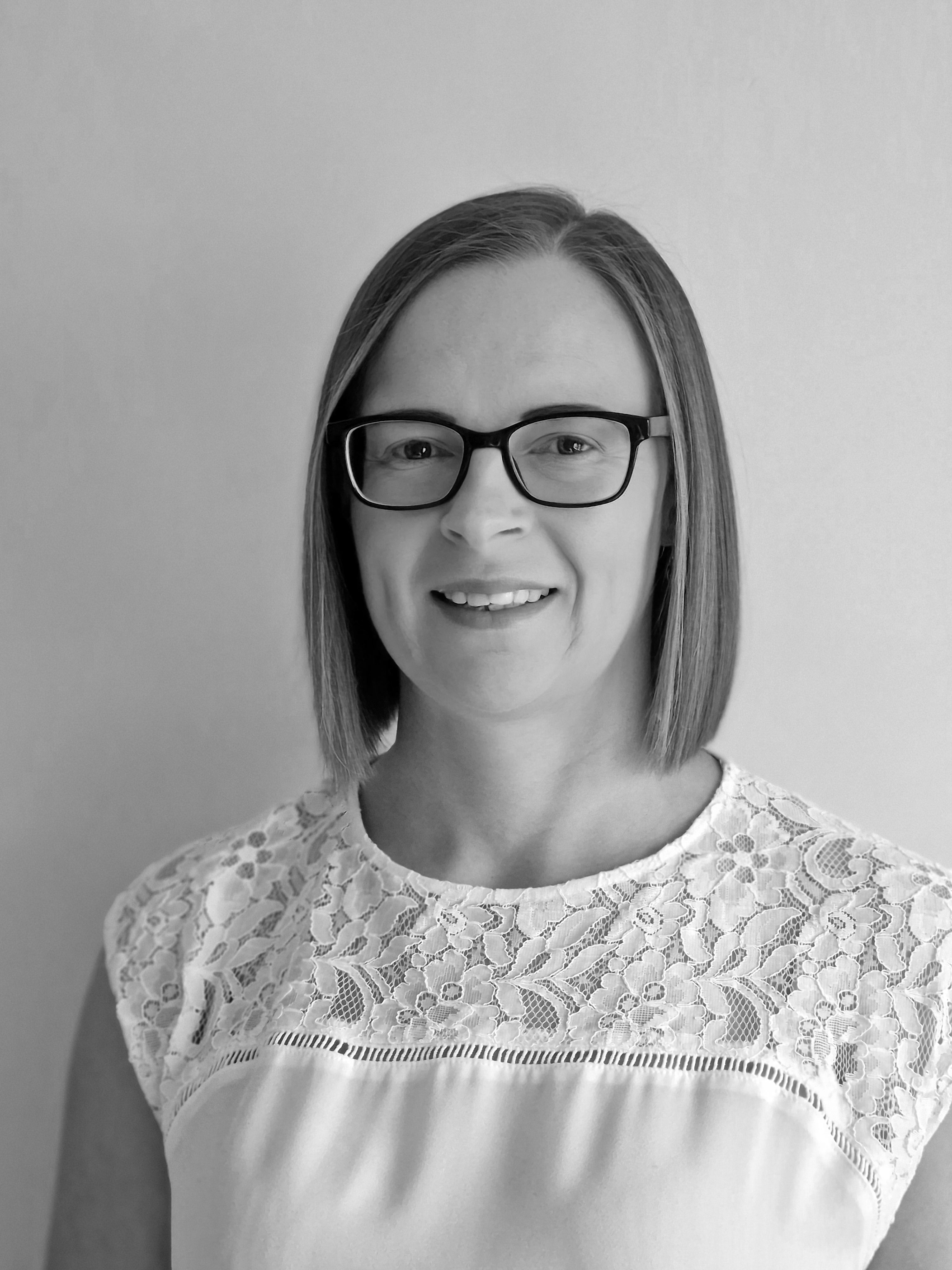 Amy Woods, a woman with mid-length brown hair wearing a white top and glasses.